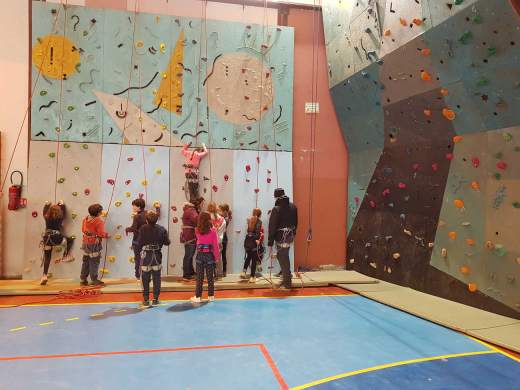 Mur descalade à lintérieur du gymnase avec des enfants qui grimpent